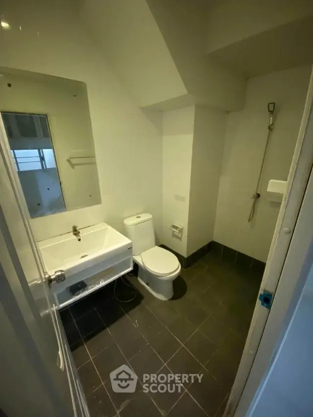 Compact modern bathroom with sleek fixtures, tiled flooring, and a well-lit ambiance, perfect for urban living.