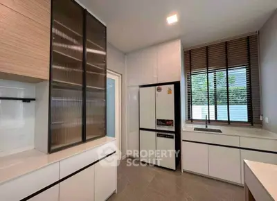 Modern kitchen with sleek cabinetry and large window for natural light.