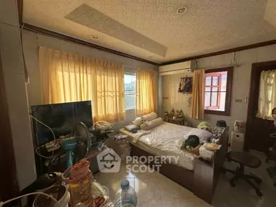 Cozy bedroom with natural light, featuring a comfortable bed, air conditioning, and ample storage space.