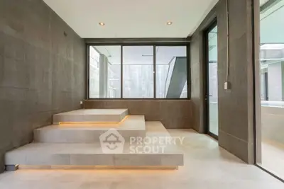 Modern minimalist interior with sleek stone steps and large windows in luxury home.
