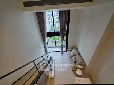 Stunning loft apartment with high ceilings and large windows offering a beautiful city view.