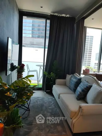 Modern living room with city view, stylish sofa, and balcony access in urban apartment.