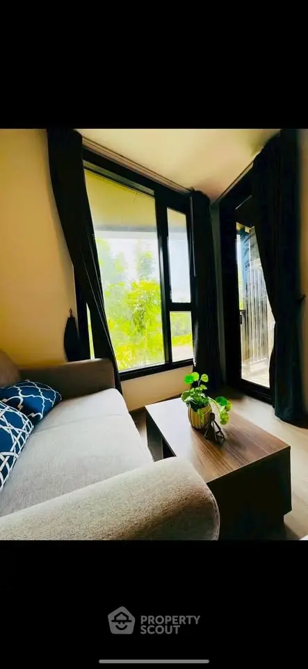 Cozy living room with large window and modern decor, perfect for relaxation.