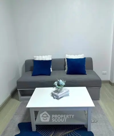 Cozy living room with modern gray sofa and stylish white coffee table, perfect for relaxation.