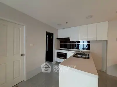 Modern kitchen with sleek white cabinets and island in a contemporary apartment