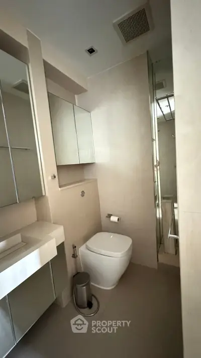 Modern bathroom with sleek fixtures and mirrored cabinets