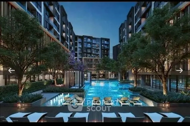 Luxurious modern apartment complex with stunning pool and lush landscaping at night.