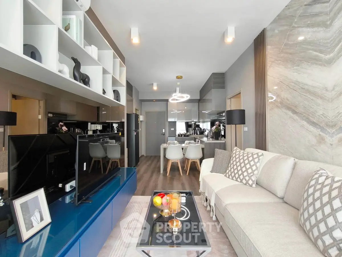 Modern living room with stylish decor and open layout, featuring a cozy sofa and elegant dining area.