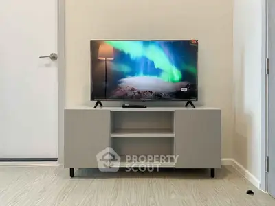 Modern living room with stylish TV stand and flat-screen television displaying northern lights.
