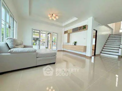 Spacious modern living room with elegant staircase and natural light