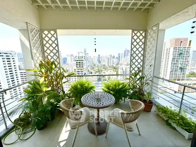Stunning balcony with city skyline view, lush greenery, and stylish seating area.