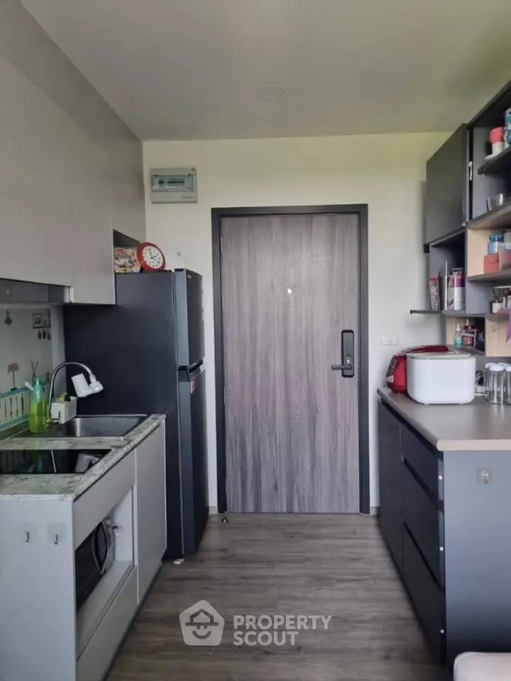 Modern kitchen with sleek appliances and ample storage in a stylish apartment.