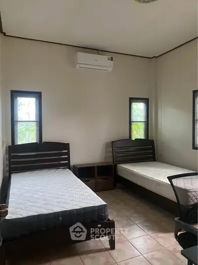 Cozy bedroom with twin beds and air conditioning, perfect for a comfortable stay.