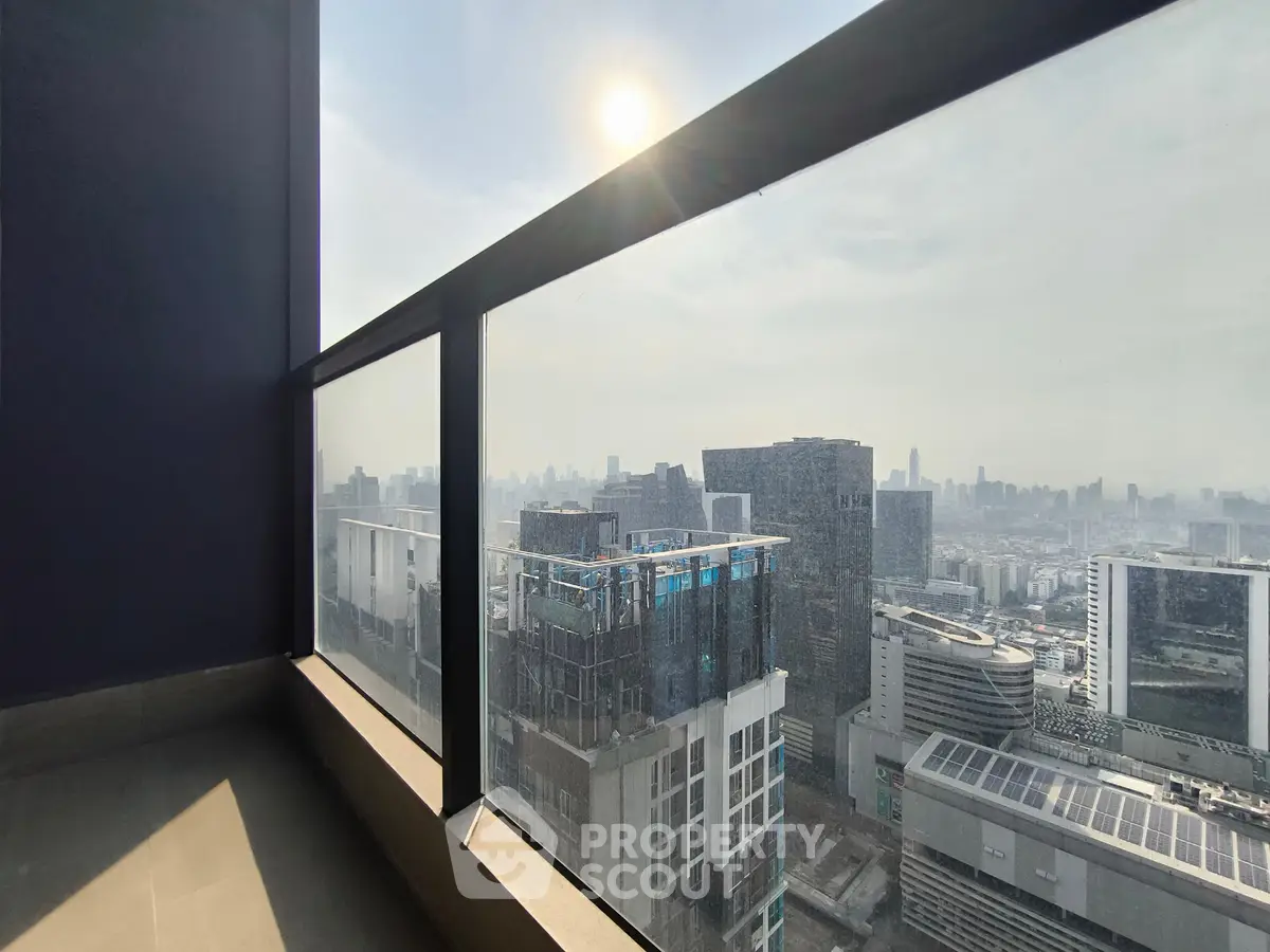 Stunning cityscape view from high-rise balcony with modern glass railing.