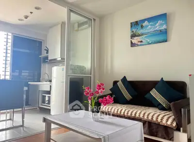 Modern living room with cozy sofa, vibrant decor, and sleek kitchen area in open layout apartment.