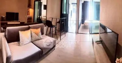 Modern living room with stylish decor and open layout leading to bedroom