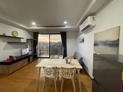 Modern living room with balcony view, stylish furniture, and air conditioning in a cozy apartment.