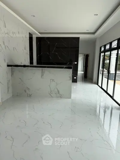Modern open-plan living area with marble flooring and large windows