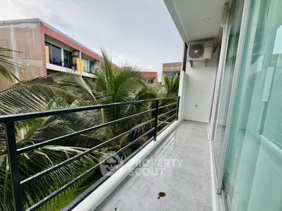 Spacious balcony with lush green views in modern apartment complex