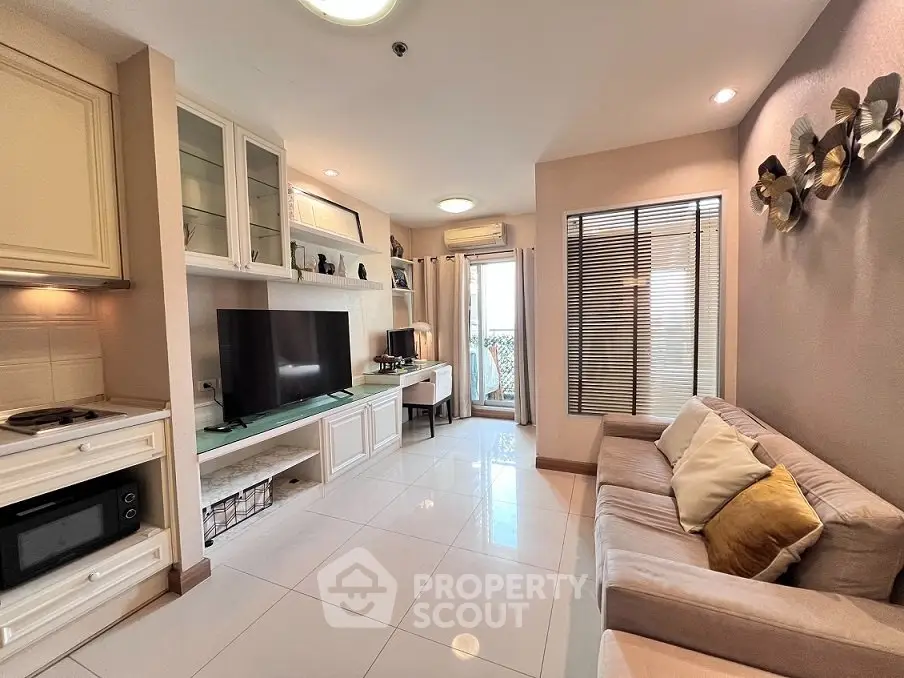 Modern living room with cozy sofa, large TV, and elegant decor in a bright apartment.