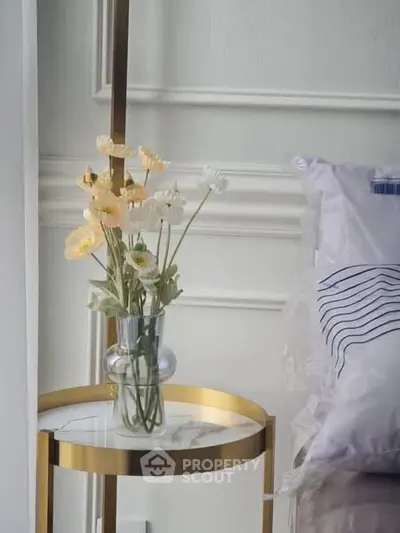 Elegant bedroom corner with stylish side table and floral decor
