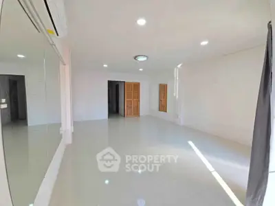 Spacious and bright living room with modern lighting and large windows.