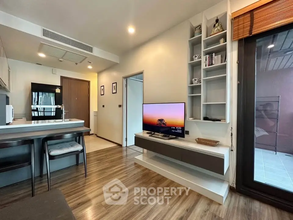 Modern living room with sleek design and open kitchen layout in a stylish apartment.