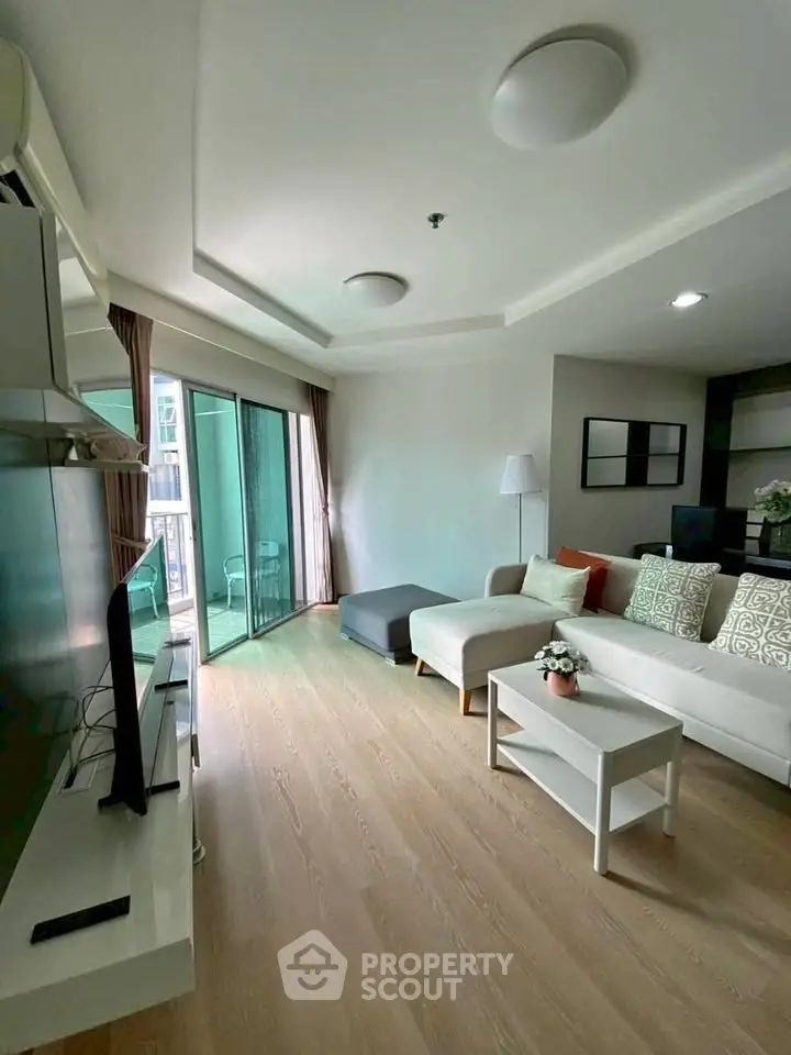 Spacious living room with modern decor and balcony access