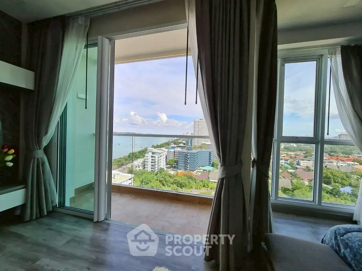 Spacious living room with large windows offering stunning ocean view and balcony access.