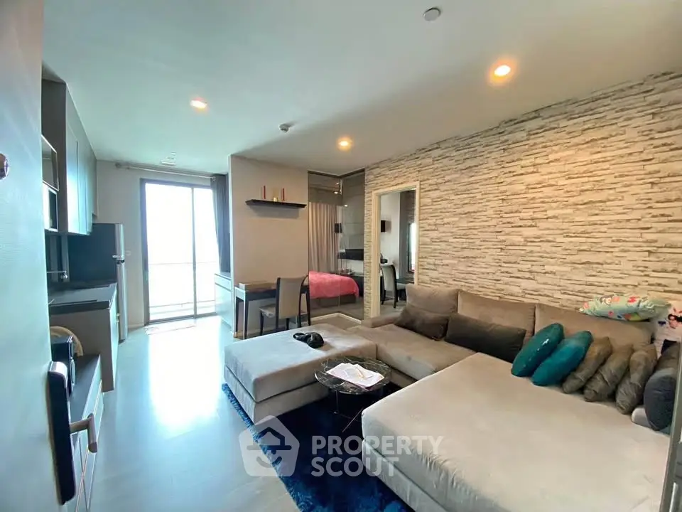 Modern living room with cozy sectional sofa and stylish decor in open-concept apartment.