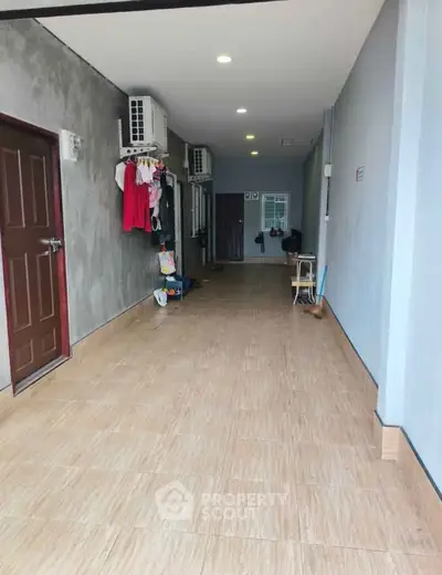 Spacious corridor with tiled flooring and air conditioning units, ideal for multi-purpose use.