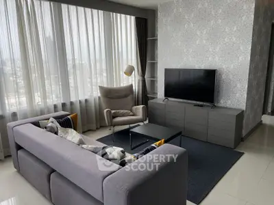 Modern living room with stylish furniture and large windows offering city views.