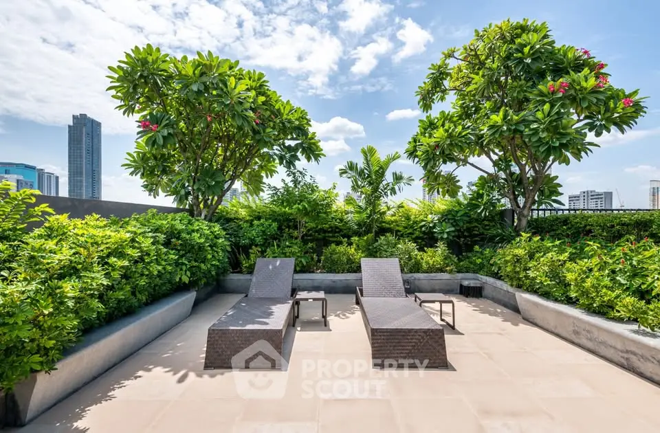 Luxurious rooftop terrace with sun loungers and lush greenery offering a serene urban escape.