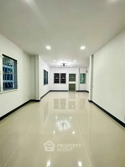 Spacious modern living room with glossy tiled floors and large windows