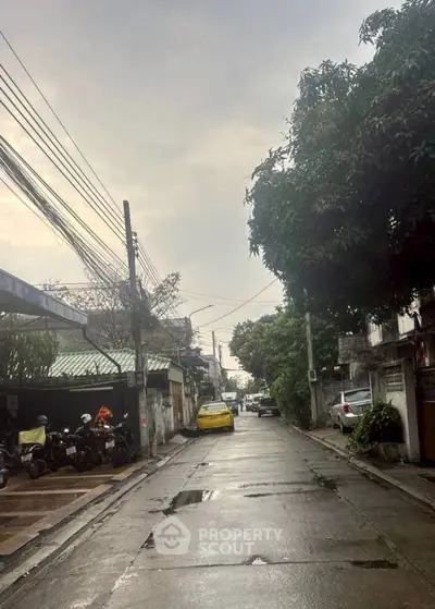 Charming urban street view with parked vehicles and lush greenery, perfect for city living enthusiasts.