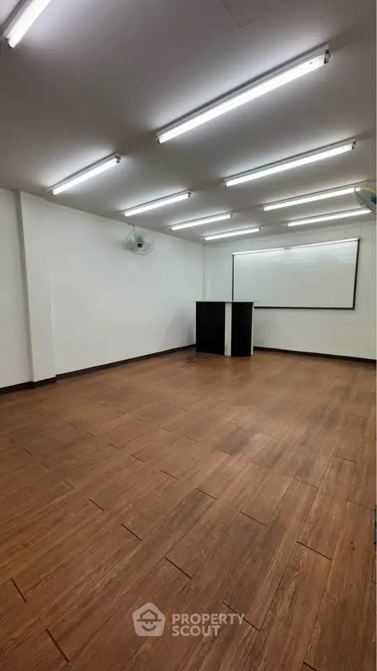 Spacious room with wooden flooring and bright lighting, ideal for office or study space.