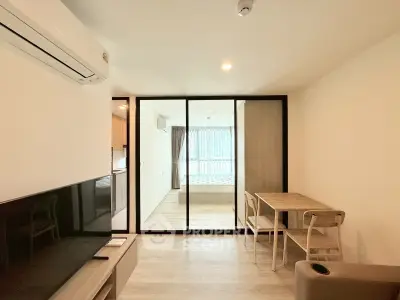 Modern studio apartment with glass partition, wooden flooring, and cozy dining area.