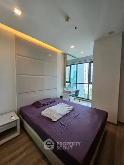 Modern bedroom with city view and sleek design in high-rise apartment.