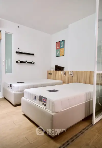 Modern bedroom with twin beds and minimalist decor, perfect for cozy living.