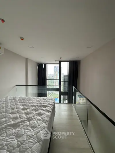 Modern loft bedroom with large windows and city view