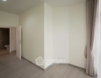 Spacious empty room with modern flooring and natural light, ideal for customization.