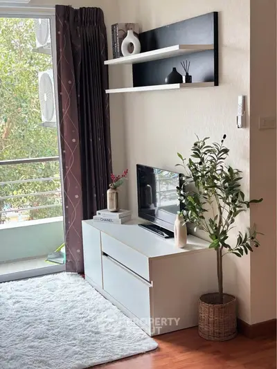 Stylish living room with modern decor, white furniture, and balcony view, perfect for urban living.