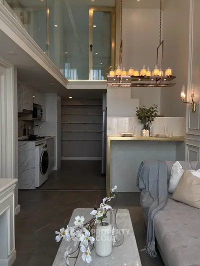 Luxurious modern living room with mezzanine, elegant decor, and open kitchen layout.