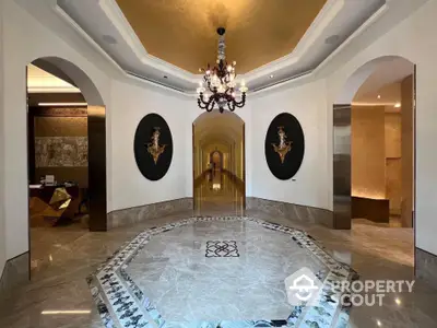 Luxurious hallway with elegant chandelier and marble flooring in upscale property