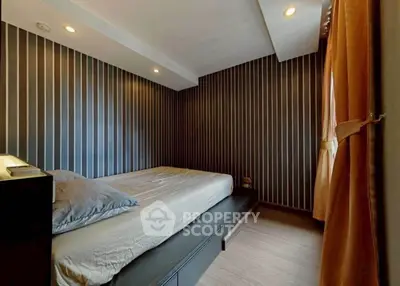 Modern bedroom with stylish striped wallpaper and cozy lighting