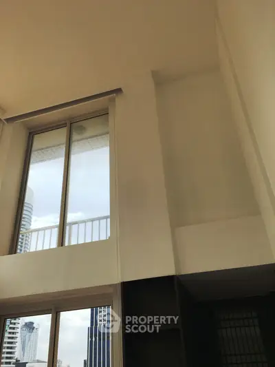 Spacious high-ceiling apartment with large windows and city view