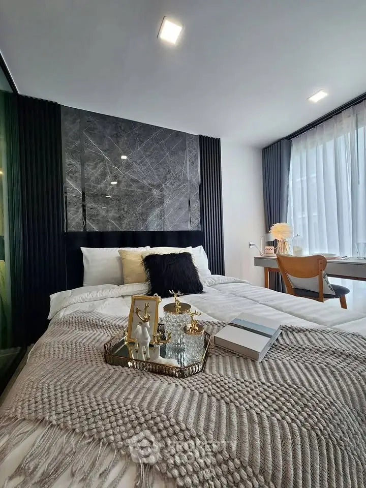 Luxurious bedroom with elegant decor and natural light, featuring a cozy bed and stylish furnishings.