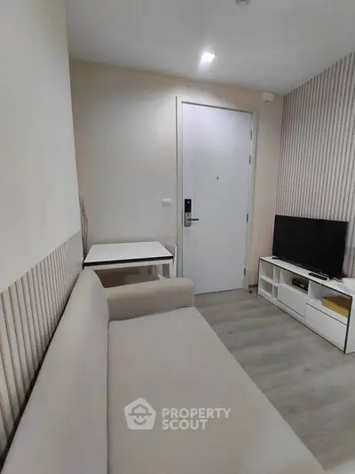 Cozy living room with modern decor, featuring a comfortable sofa and sleek TV stand.