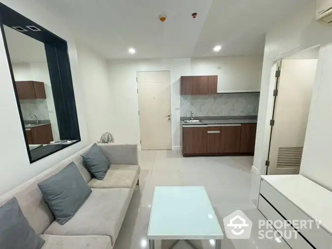 Sleek modern apartment featuring a bright living room with plush seating and a fully equipped kitchen with stylish cabinetry and countertops.