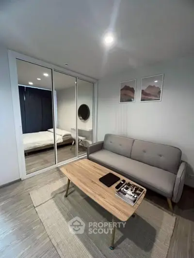 Modern living room with cozy sofa, coffee table, and mirrored closet in stylish apartment.